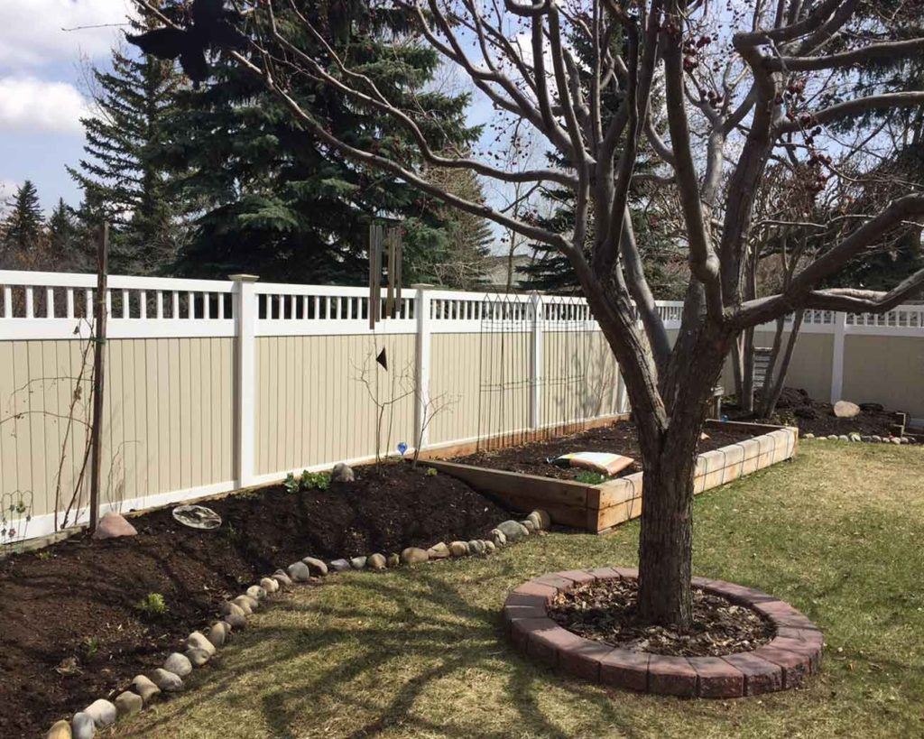 a tree with a white and beige outdoor fence